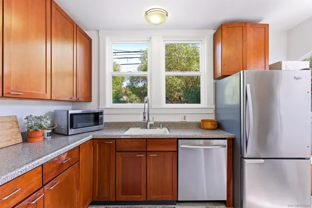 a kitchen with stainless steel appliances granite countertop a refrigerator and a sink