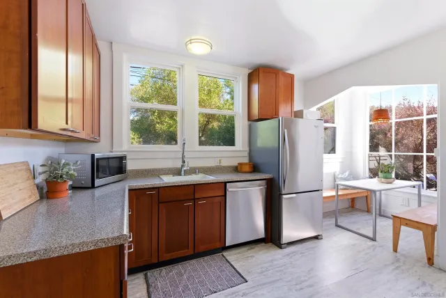 a kitchen with stainless steel appliances granite countertop a refrigerator and a sink
