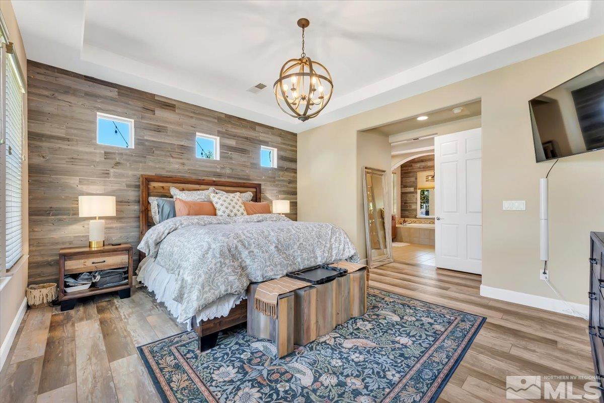 10675 Solano Court Reno, NV 89521 - Photo 16 of 39 a bedroom with a bed and a table with wooden floor
