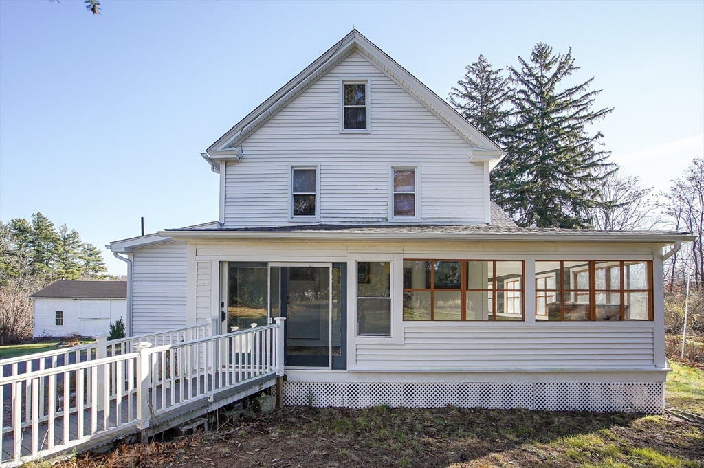 a view of a house with a small yard and wooden fence
