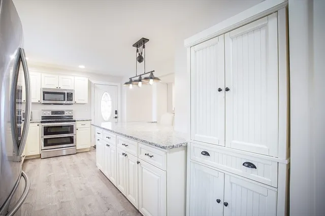 a kitchen with stainless steel appliances a refrigerator and cabinets