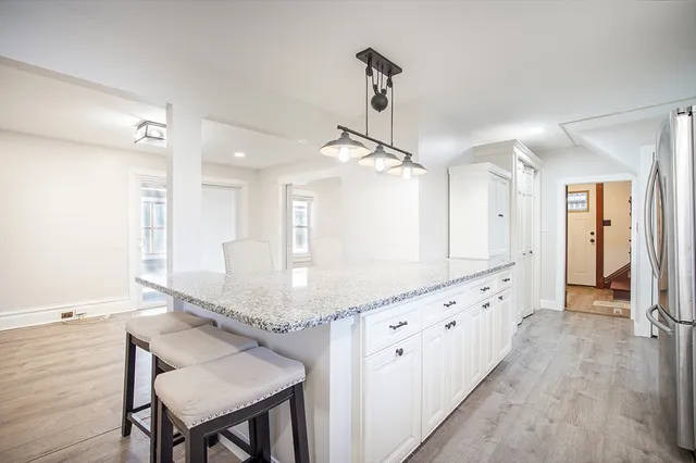 a kitchen with granite countertop a table chairs stainless steel appliances and cabinets