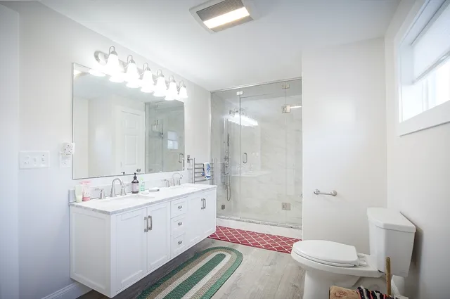 a spacious bathroom with a double vanity sink mirror and toilet