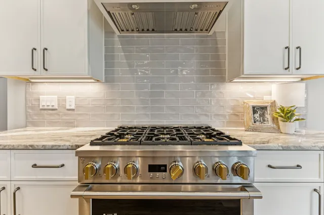 a kitchen with stainless steel appliances granite countertop a stove and a refrigerator