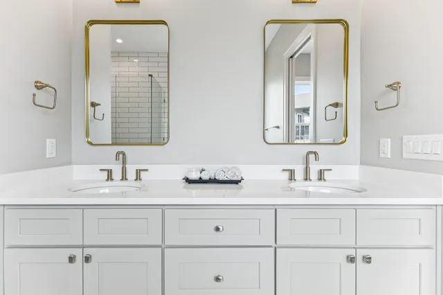 a bathroom with double vanity sinks and a mirror