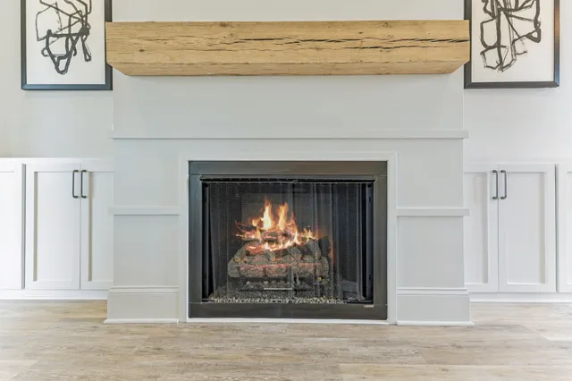 a large kitchen with kitchen island a stove a sink a refrigerator and white cabinets with wooden floor