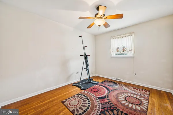 a view of a room with wooden floor and ceiling fan