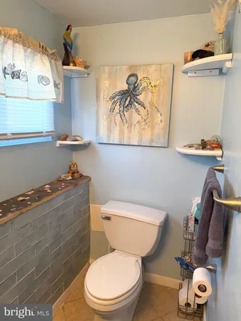 a white toilet sitting next to a bathroom sink and vanity