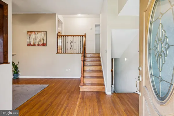 a view of a hallway with wooden floor and staircase