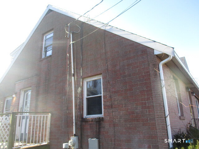 71 Broad Street Meriden, CT 06450 - Photo 3 of 21 a brick house with a windows and a small yard