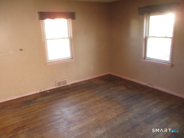 71 Broad Street Meriden, CT 06450 - Photo 7 of 21 an empty room with wooden floor and windows
