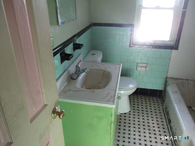71 Broad Street Meriden, CT 06450 - Photo 9 of 21 a bathroom with a sink toilet and window