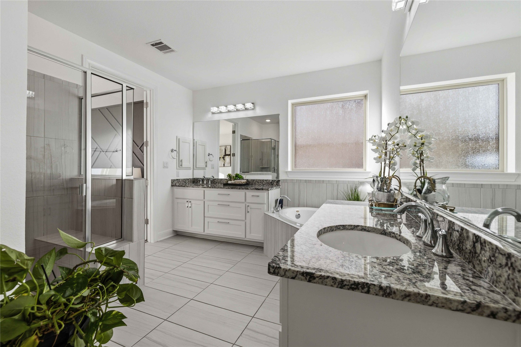 1517 Bardella Drive Leander, TX 78641 - Photo 14 of 40 Full bath with two vanities, a bath, a shower stall, and light tile patterned flooring