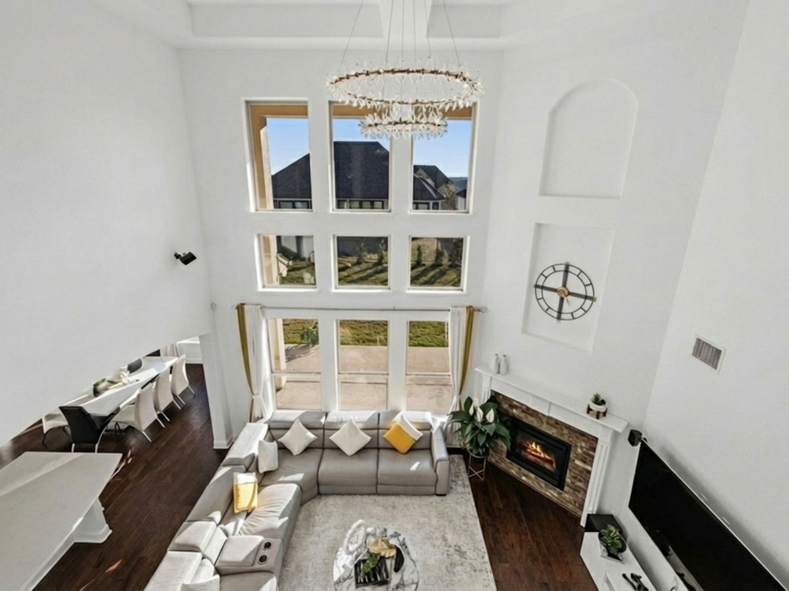 1517 Bardella Drive Leander, TX 78641 - Photo 7 of 40 Living area featuring a high ceiling, a glass covered fireplace, dark wood finished floors, and hanging chandelier