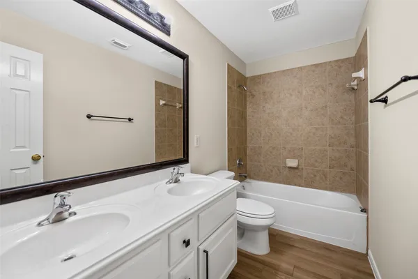 a bathroom with a double vanity sink toilet and shower