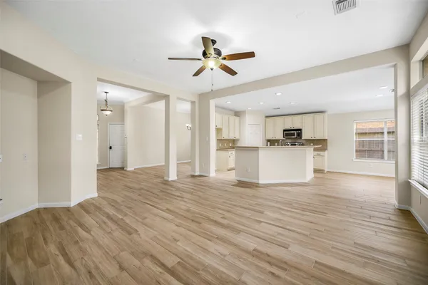 a view of a kitchen with wooden floor and a ceiling fan