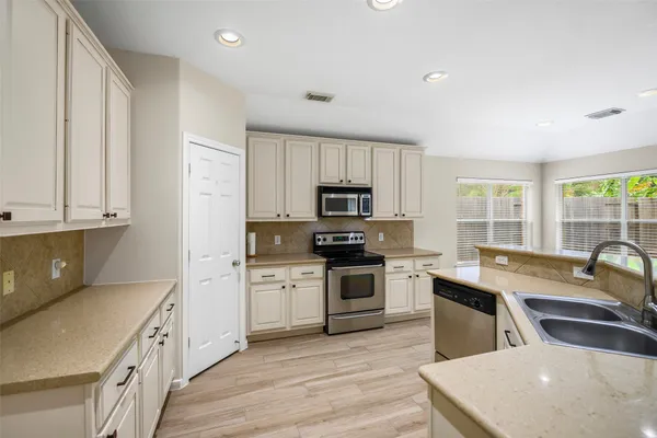 a kitchen with stainless steel appliances granite countertop a kitchen island hardwood floor sink stove and granite counter top