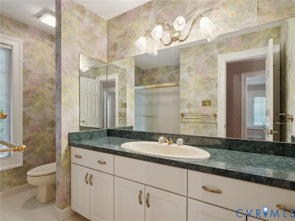 9010 Kings Crown Road North Chesterfield, VA 23236 - Photo 19 of 36 a bathroom with a granite countertop sink a toilet and a mirror