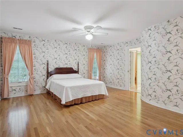 a bedroom with a bed and wooden floor