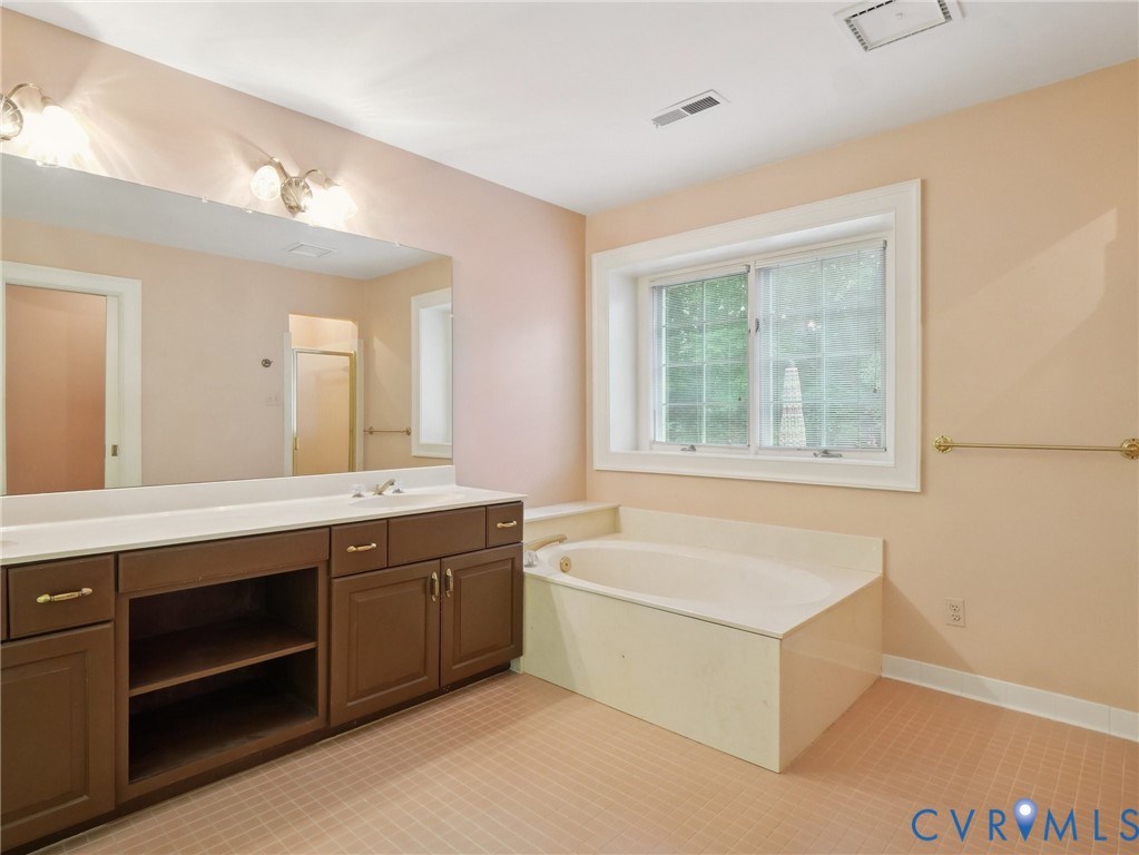 9010 Kings Crown Road North Chesterfield, VA 23236 - Photo 24 of 36 a spacious bathroom with a tub double vanity sink a window and a mirror