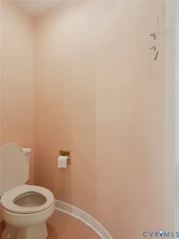 a white toilet sitting next to a white wall