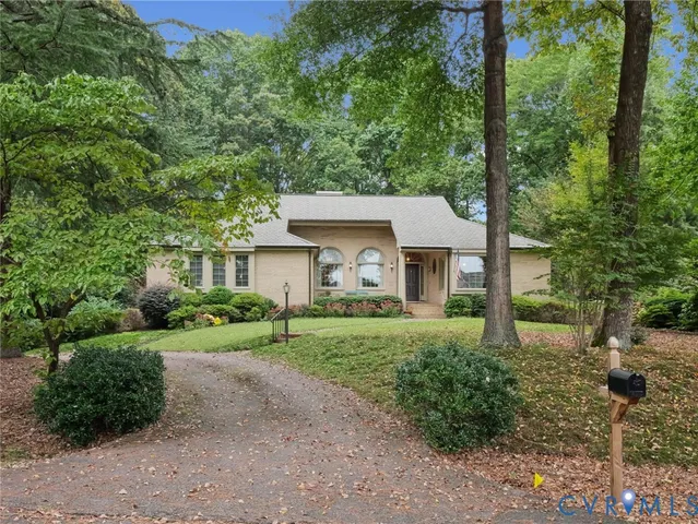 a view of a house with yard and large trees