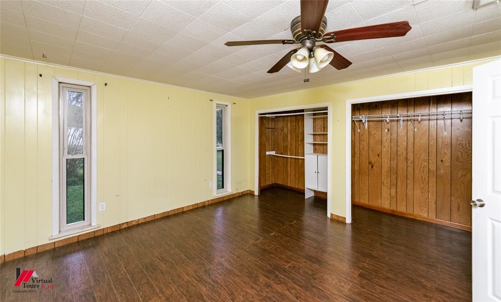1177 Princeton Road Princeton, LA 71067 - Photo 17 of 34 a view of an empty room with wooden floor and a ceiling fan