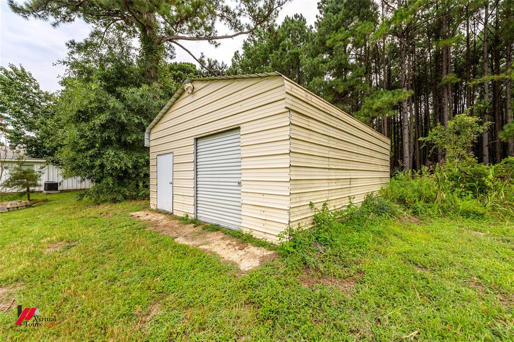 1177 Princeton Road Princeton, LA 71067 - Photo 25 of 34 a backyard of a house with plants and large tree