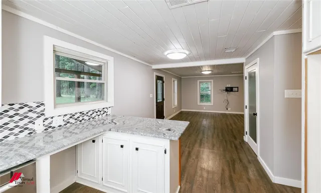 a kitchen with granite countertop a sink a stove and cabinets
