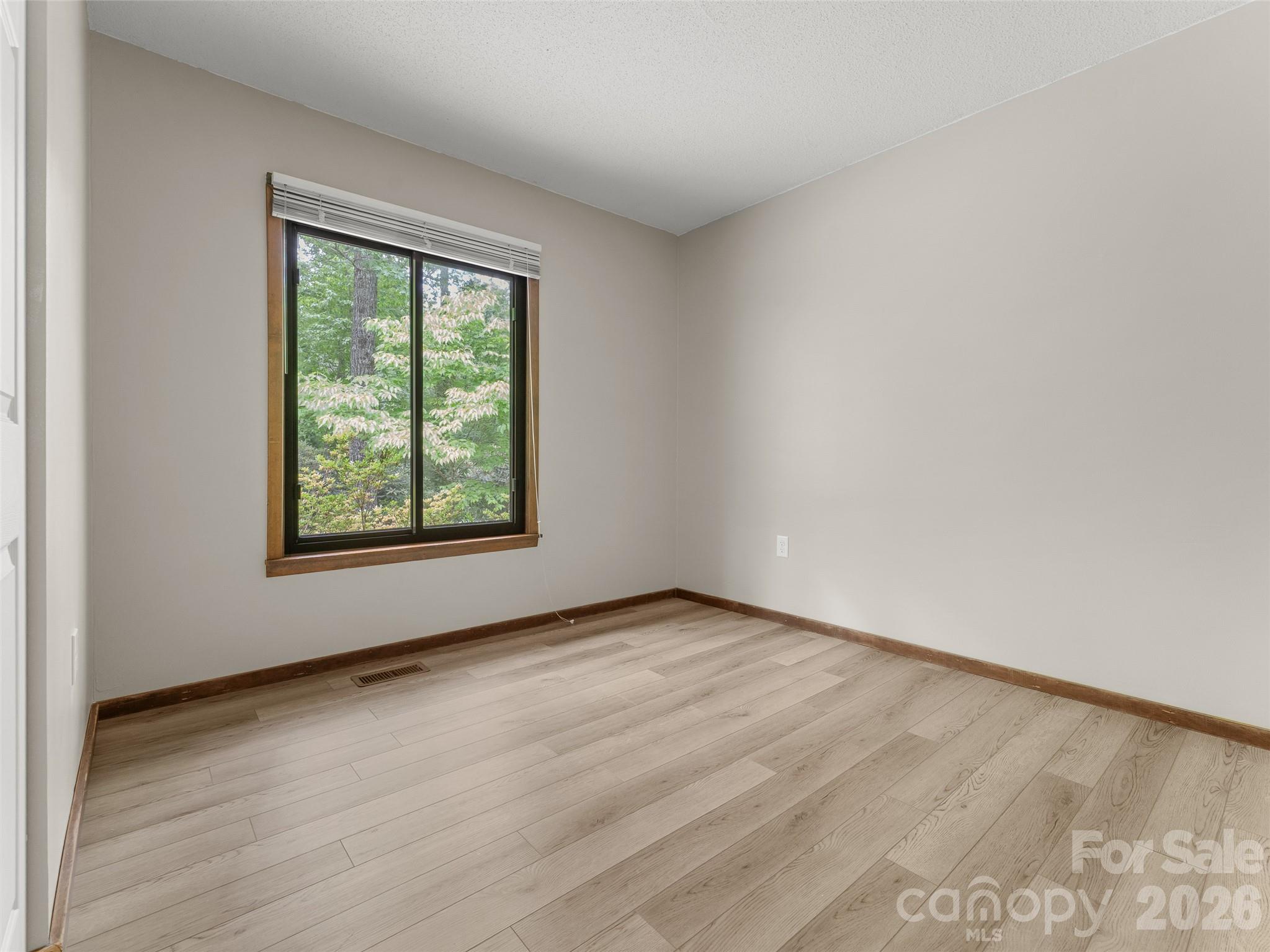 32 Honey Suckle Ridge Road Pisgah Forest, NC 28768 - Photo 21 of 35 an empty room with wooden floor and windows