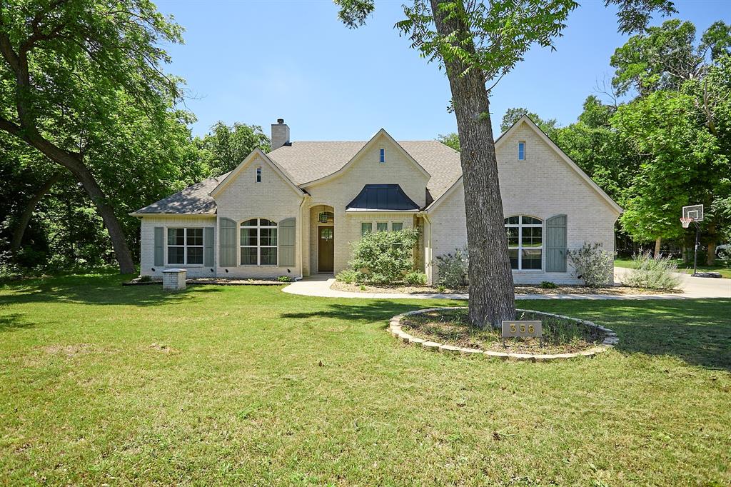 358 Glade Valley Road Azle, TX 76020 - Photo 2 of 35 Light-colored brick exterior featuring arched windows with louvered shutters, a covered entry, and a multi-level gabled roofline