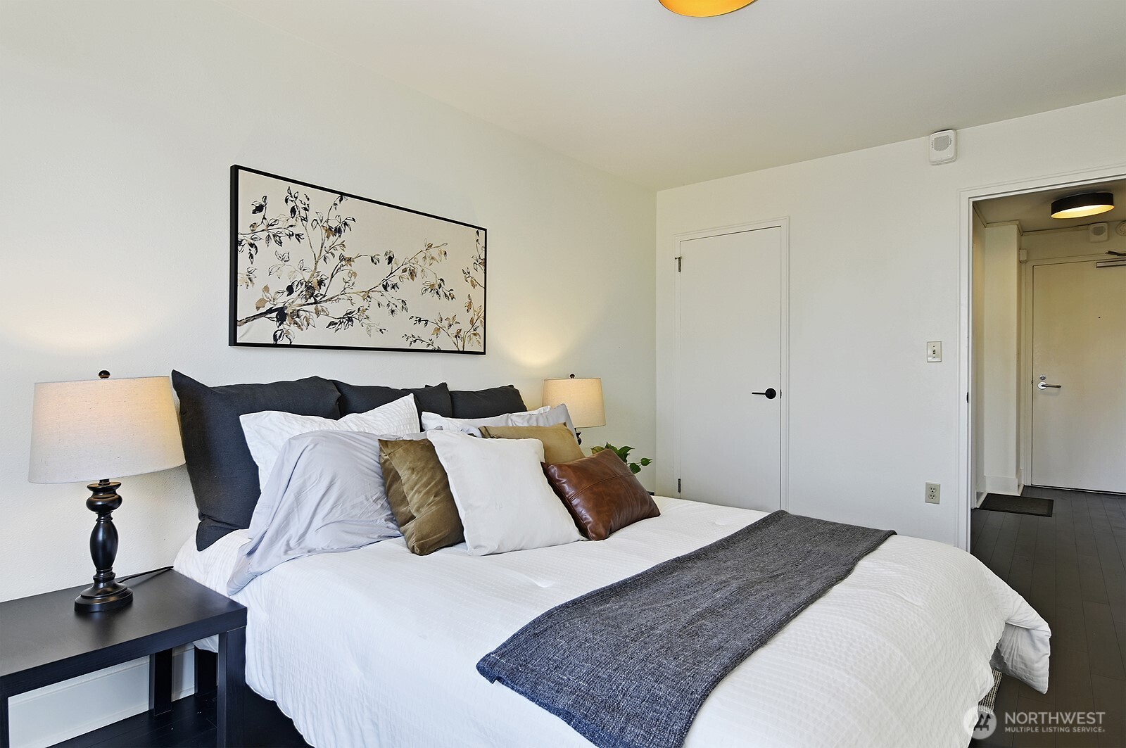 1105 Spring Street, Unit 709 Seattle, WA 98104 - Photo 16 of 30 a bedroom with a bed and painting on the wall