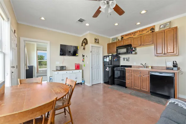 a kitchen with a refrigerator a stove top oven a sink dishwasher and white cabinets with wooden floor