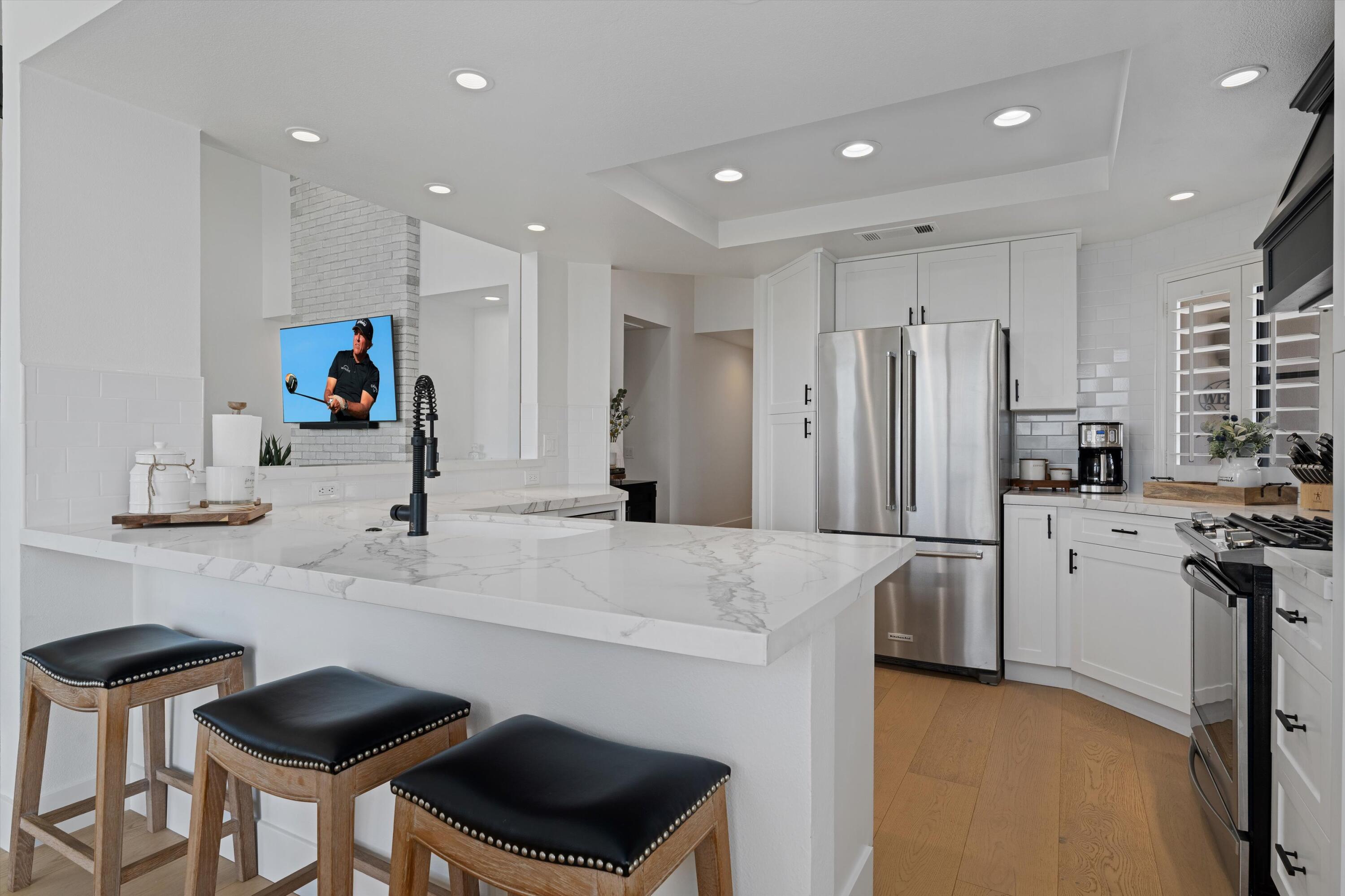 54754 Oak-Tree La Quinta, CA 92253 - Photo 20 of 33 a kitchen with stainless steel appliances kitchen island granite countertop a refrigerator and a stove top oven