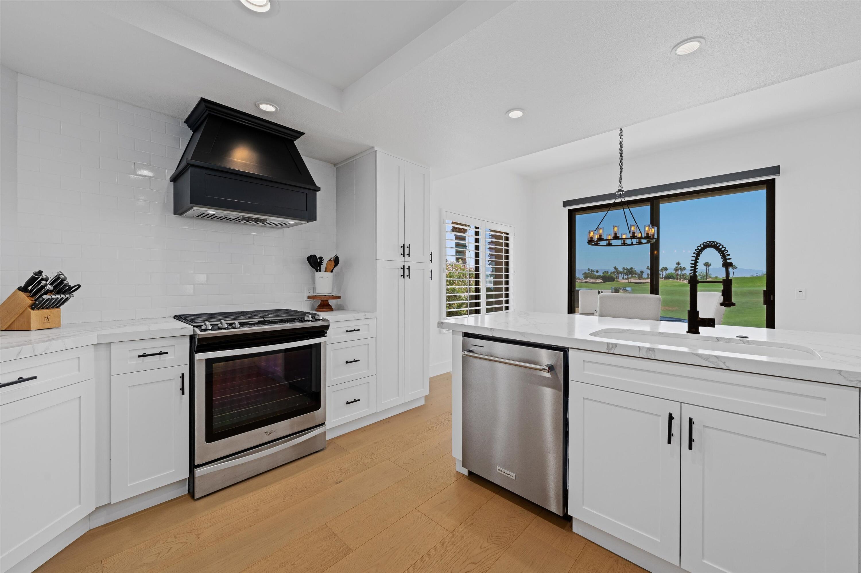 54754 Oak-Tree La Quinta, CA 92253 - Photo 21 of 33 a kitchen with a sink and a stove top oven with wooden floor