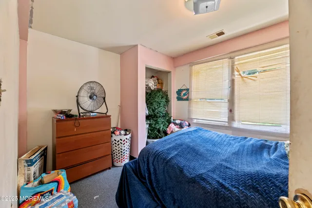 a bed sitting in a bedroom next to a window