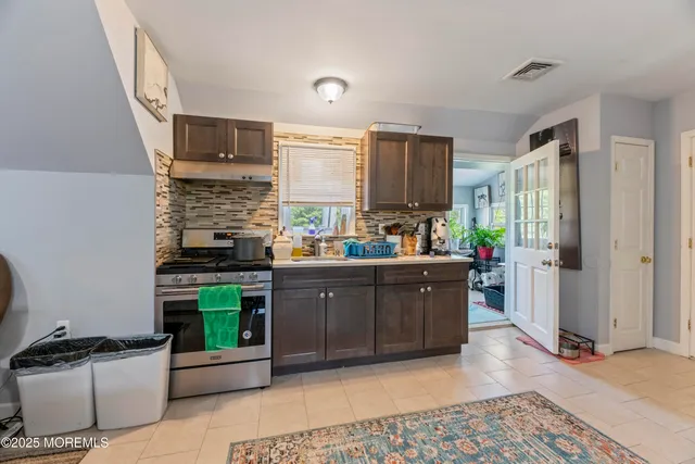 a kitchen with stainless steel appliances kitchen island granite countertop a refrigerator and a stove