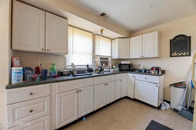 a kitchen with white cabinets and white appliances