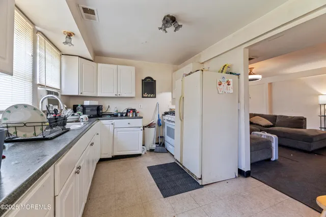 a kitchen with white cabinets and white appliances