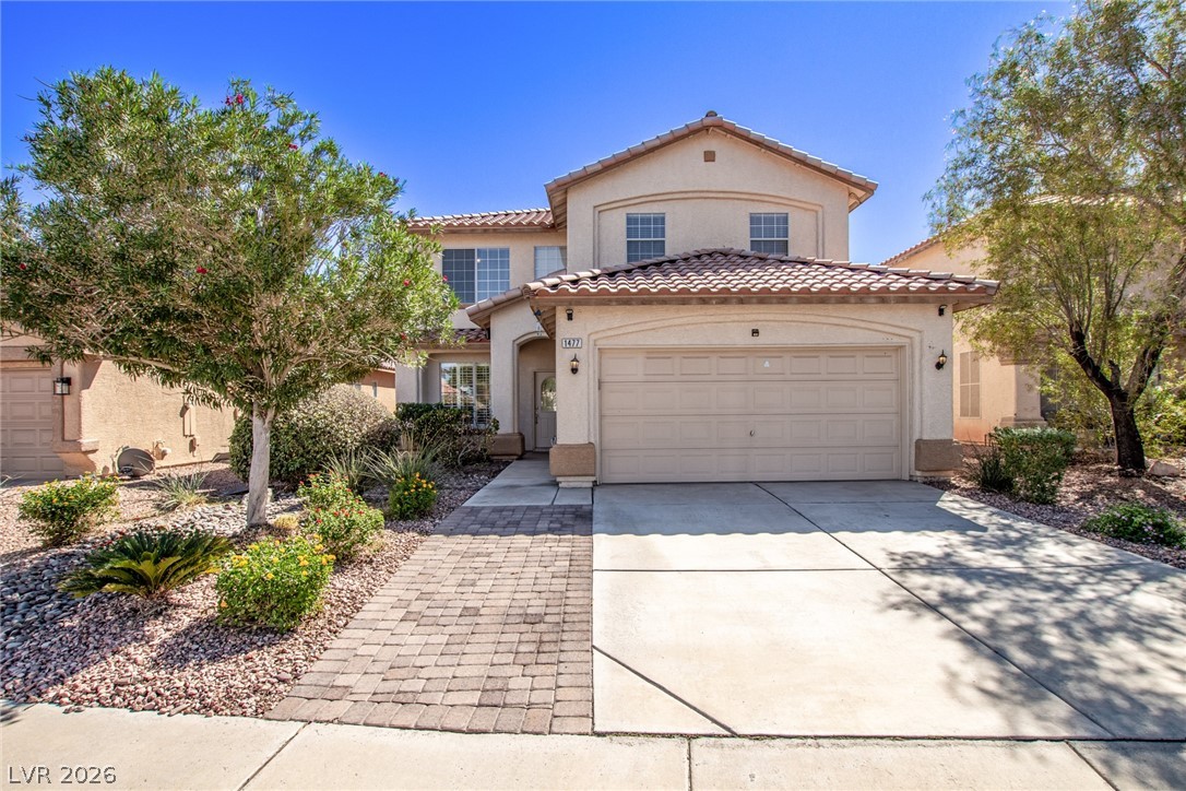 1477 Rancho Ridge Drive Henderson, NV 89012 - Photo 2 of 46 A terracotta-tiled roof and stucco exterior combine with a paver walkway to create appealing desert-friendly curb appeal.
