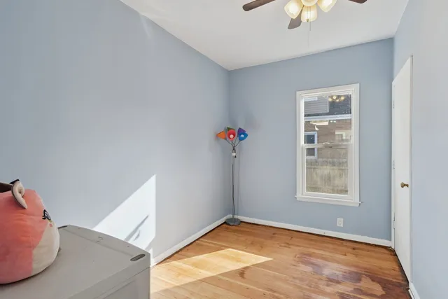 a view of a kitchen with refrigerator and wooden floor