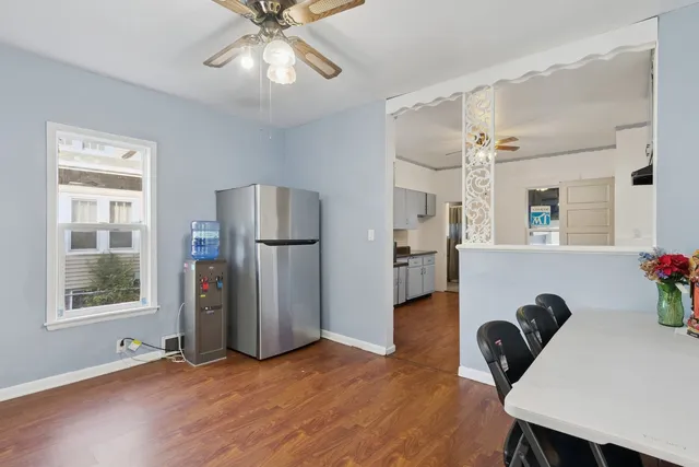a kitchen with stainless steel appliances granite countertop a sink a stove cabinets and wooden floor