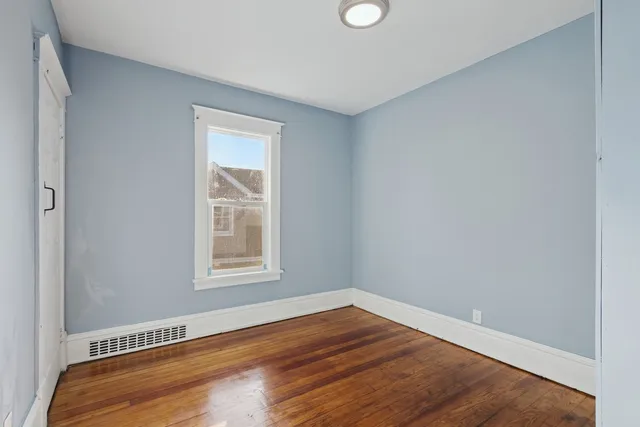 a view of an empty room with wooden floor