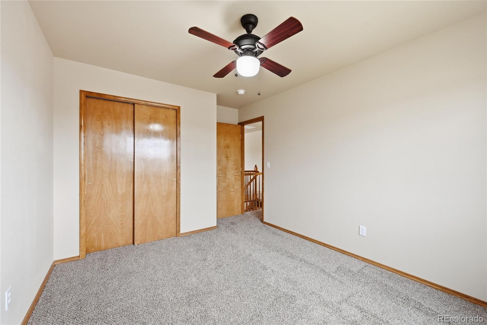 9288 Rockingham Drive Peyton, CO 80831 - Photo 26 of 49 a view of an empty room and chandelier fan