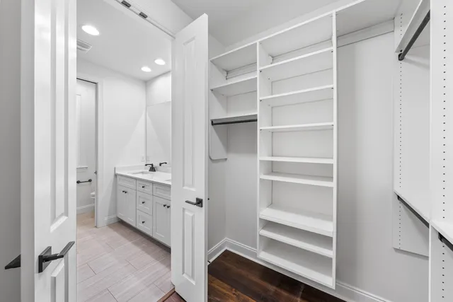 a view of walk in closet with empty racks