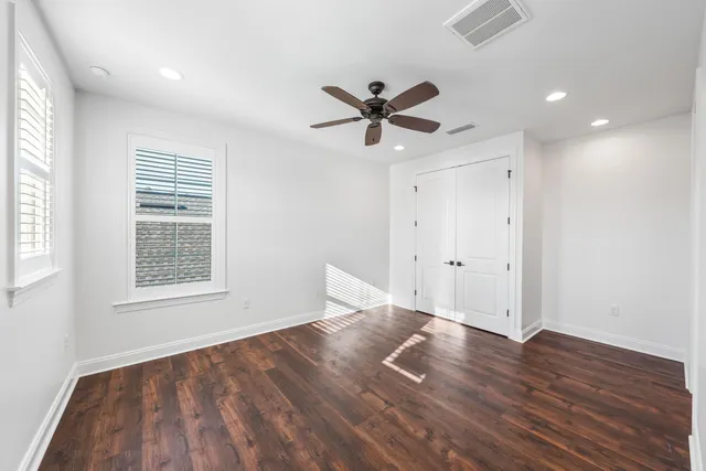 a view of empty room with wooden floor and ceiling fan