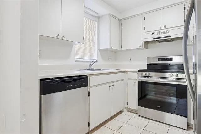 a kitchen with stainless steel appliances granite countertop a refrigerator and a stove