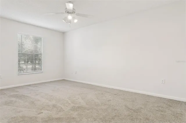 an empty room with a ceiling fan and a fan
