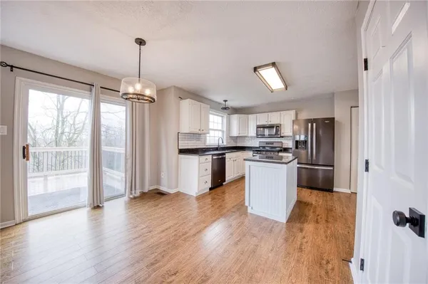 a kitchen with kitchen island white cabinets and stainless steel appliances