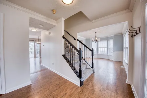 a view of a hallway with wooden floor and staircase